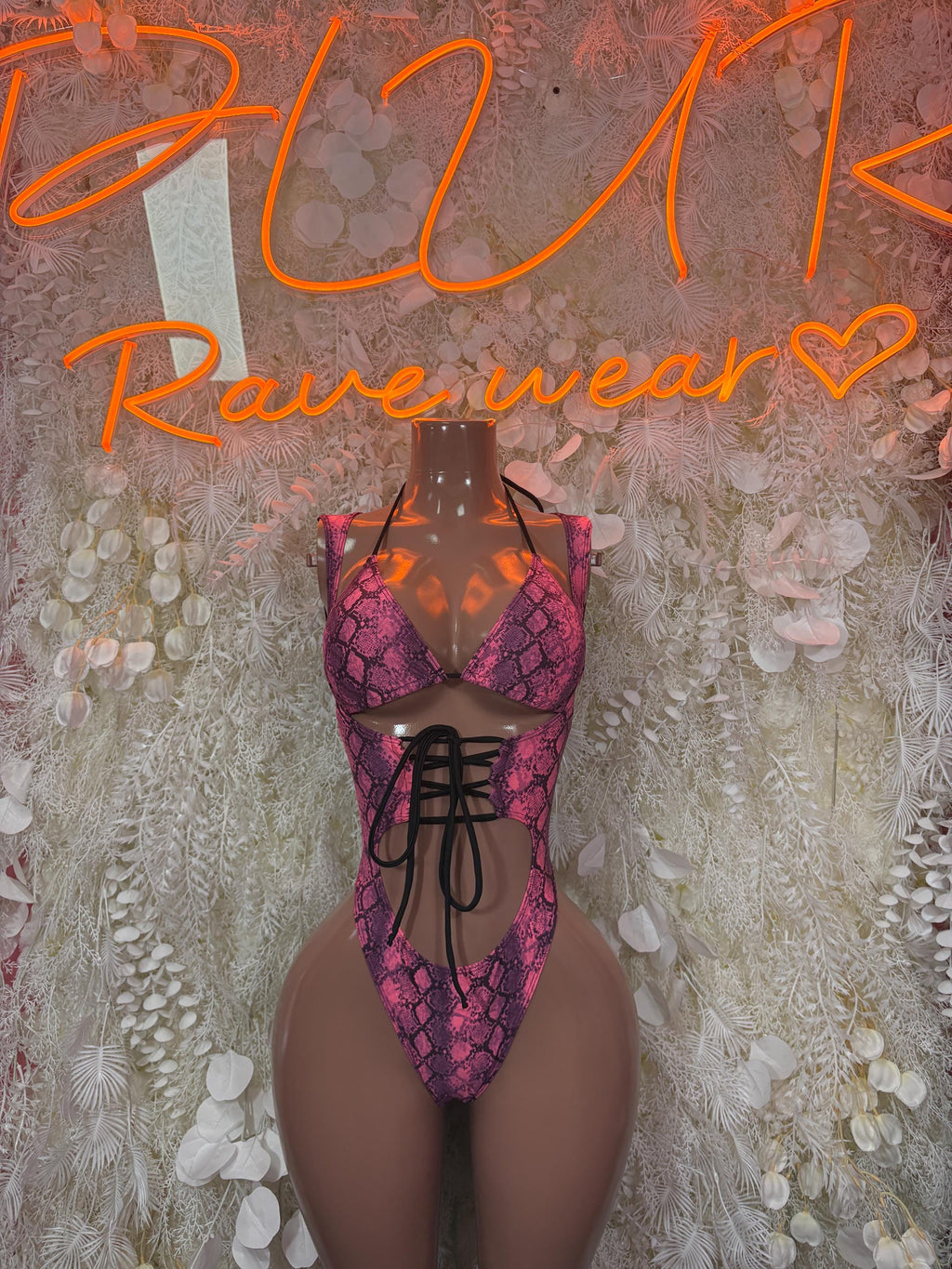 Pink snake-print one-piece bodysuit with black lace-up neckline and high-cut legs