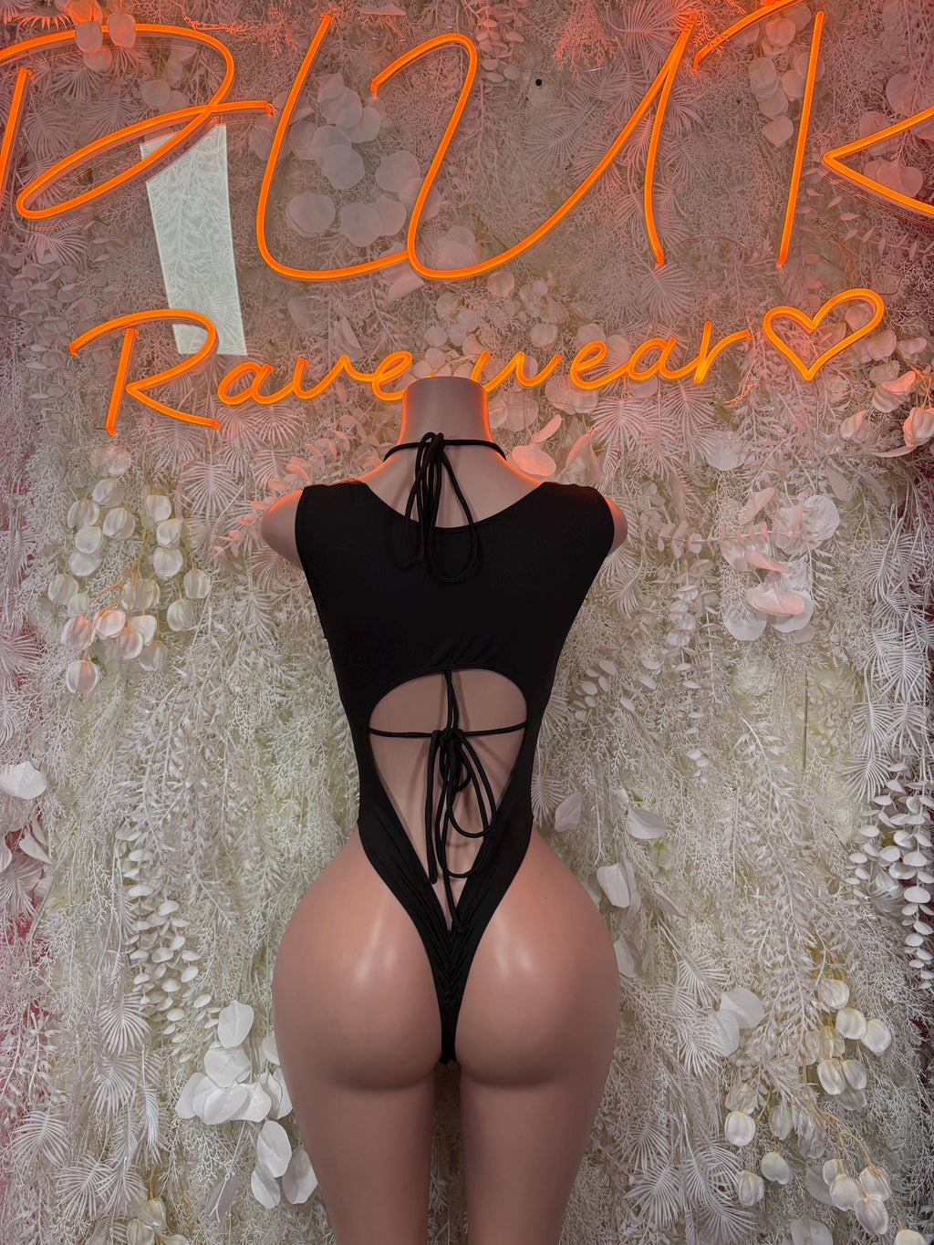 Black one-piece bodysuit with crisscross back straps and front lace-up cutout