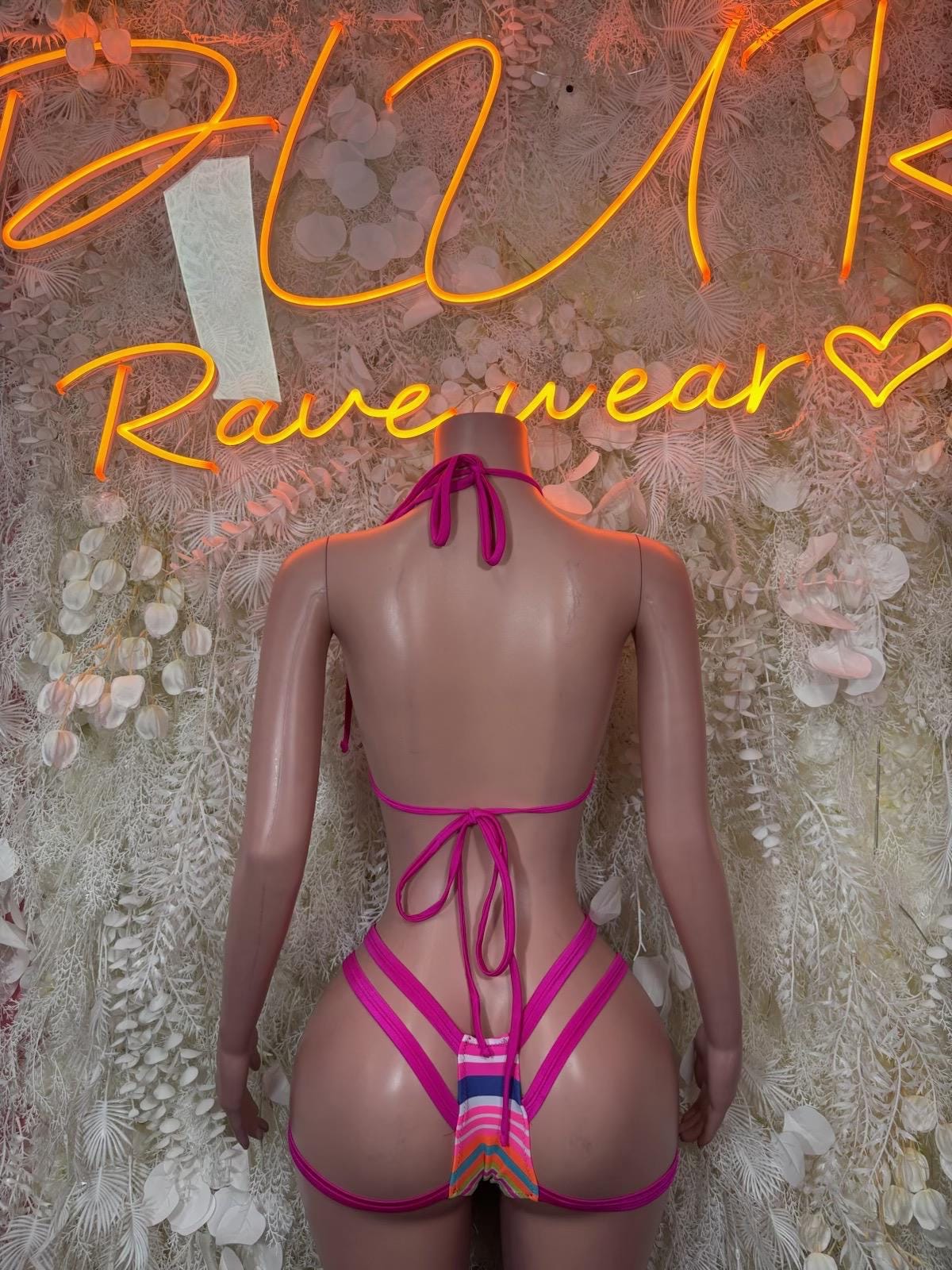 Back view of strappy rave bikini with multicolor striped triangle top and magenta ties