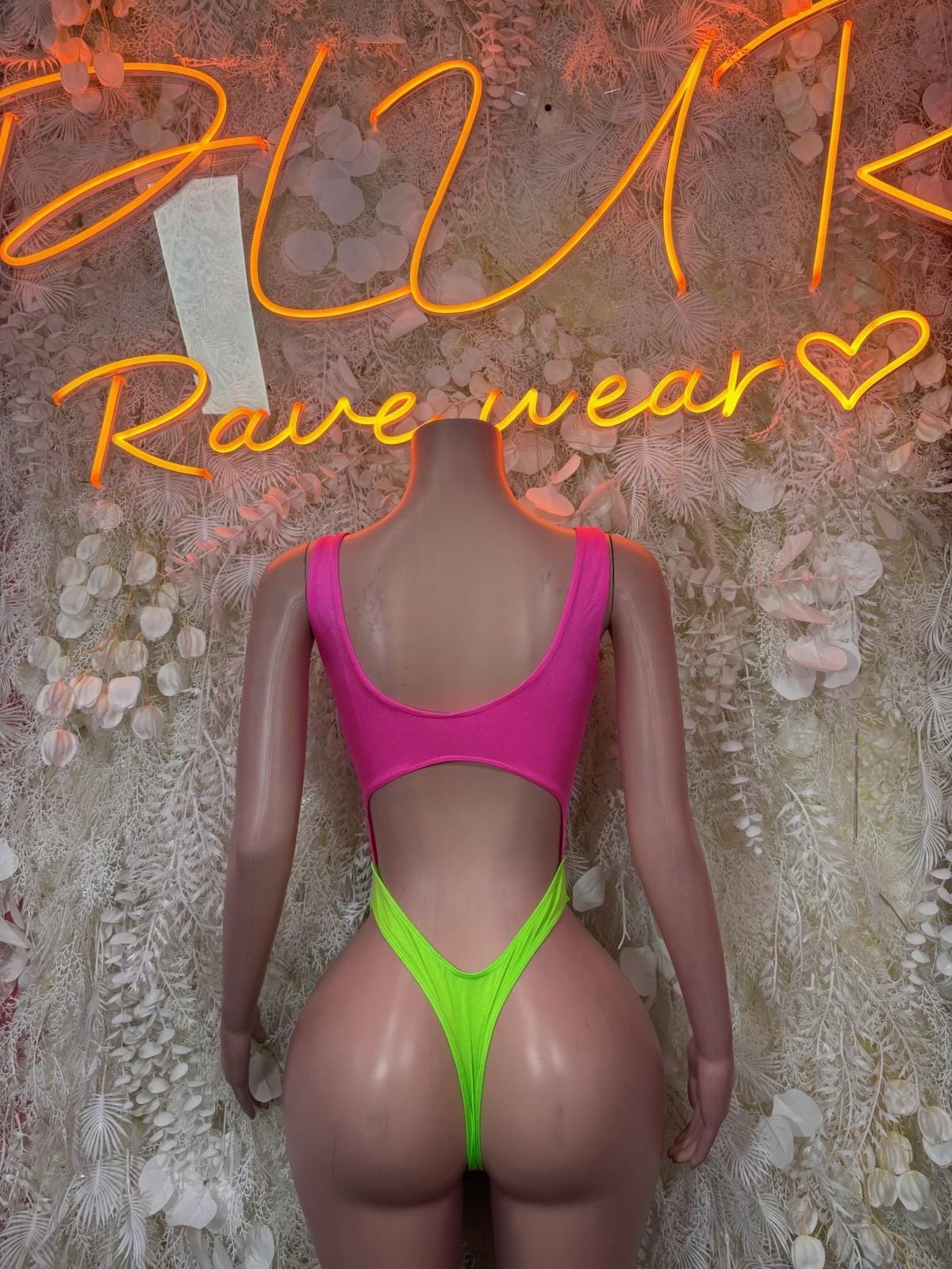 Rave one-piece bodysuit with bright pink top and neon green high-cut leg openings