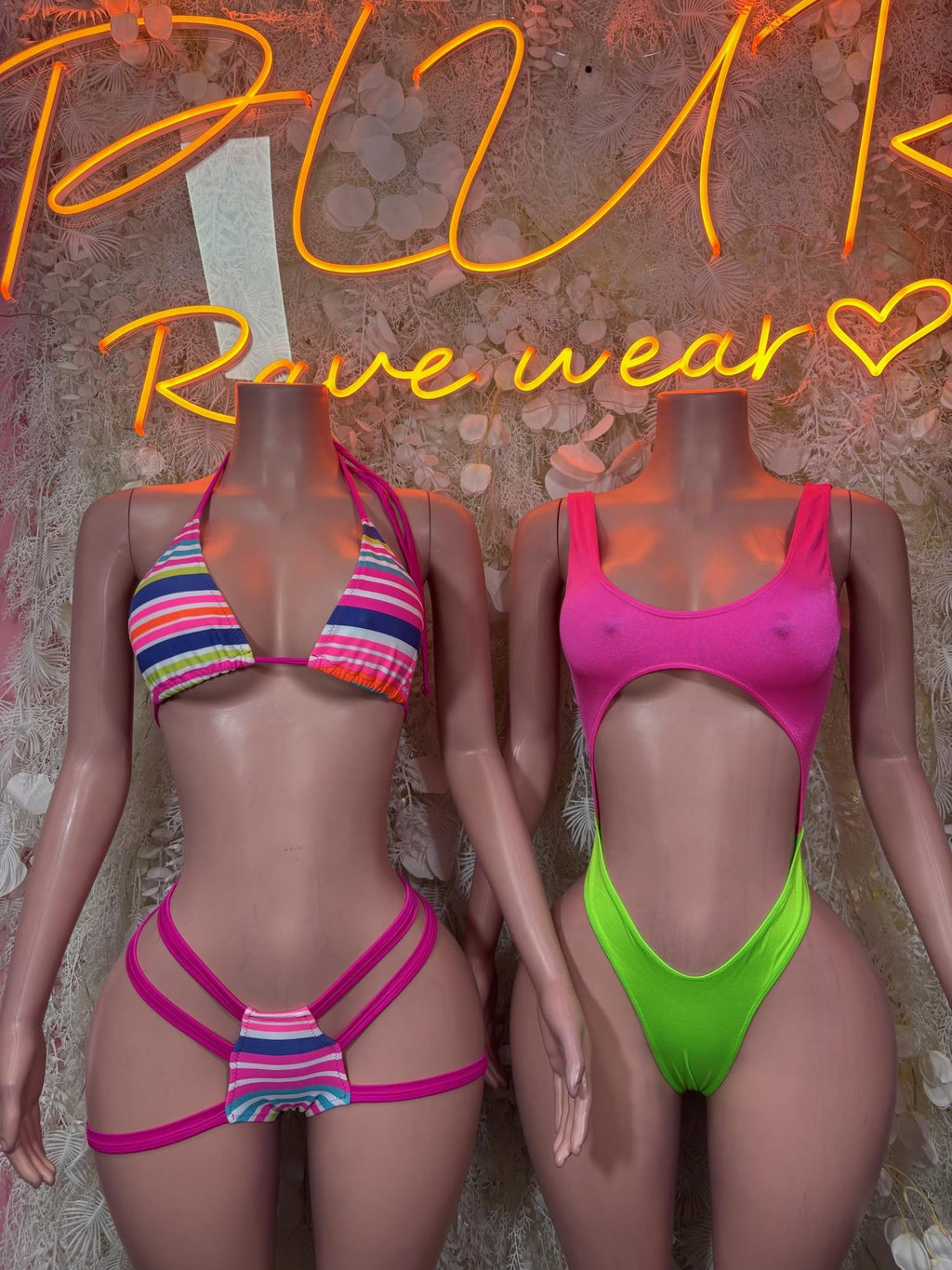 One-piece bodysuit in bright pink and neon green, beside a striped bikini set