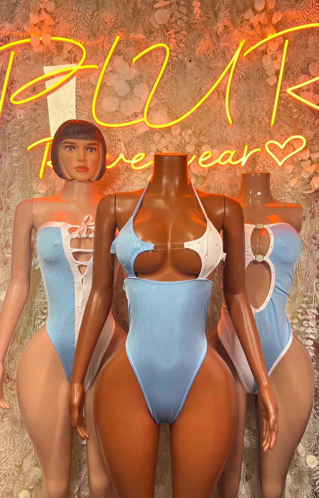 Light blue and white one-piece swimsuits on mannequins
