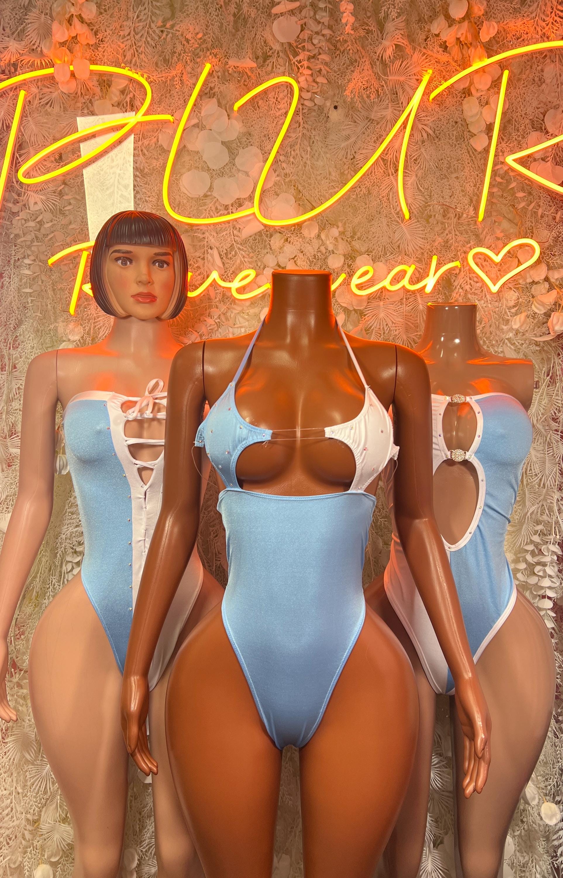Light blue and white one-piece swimsuits on mannequins