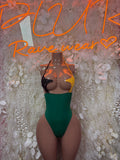 Green one-piece bodysuit with black dotted cups and halter straps