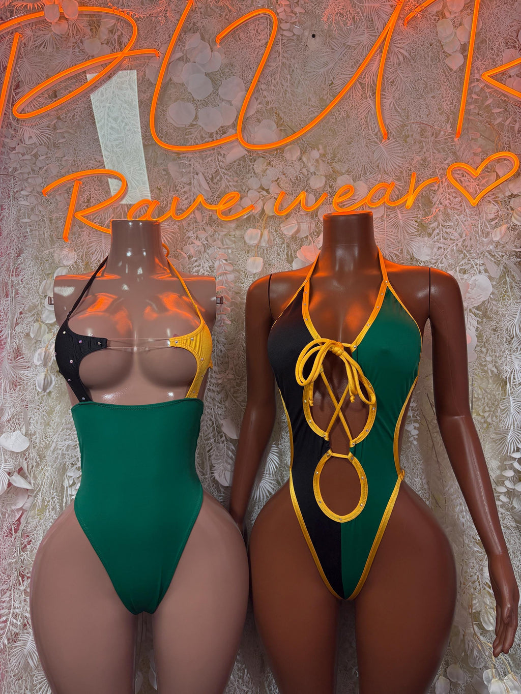 Jamaica-flag bodysuit set on two mannequins: green body with black and yellow lacing
