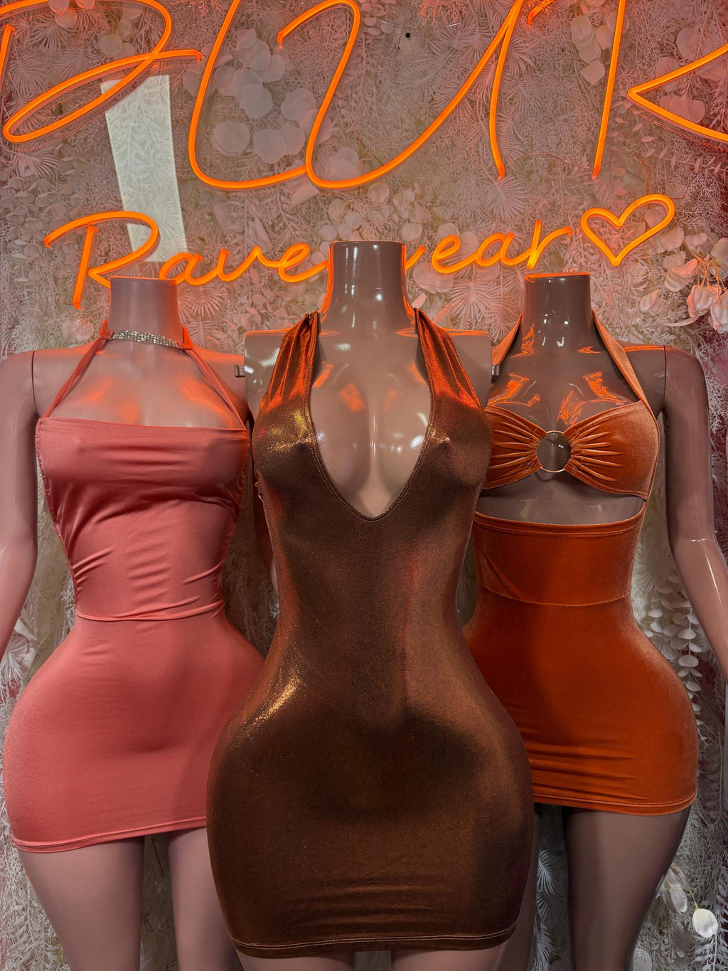 Halter cutout mini dresses in orange and pink, ruched bodice on three mannequins