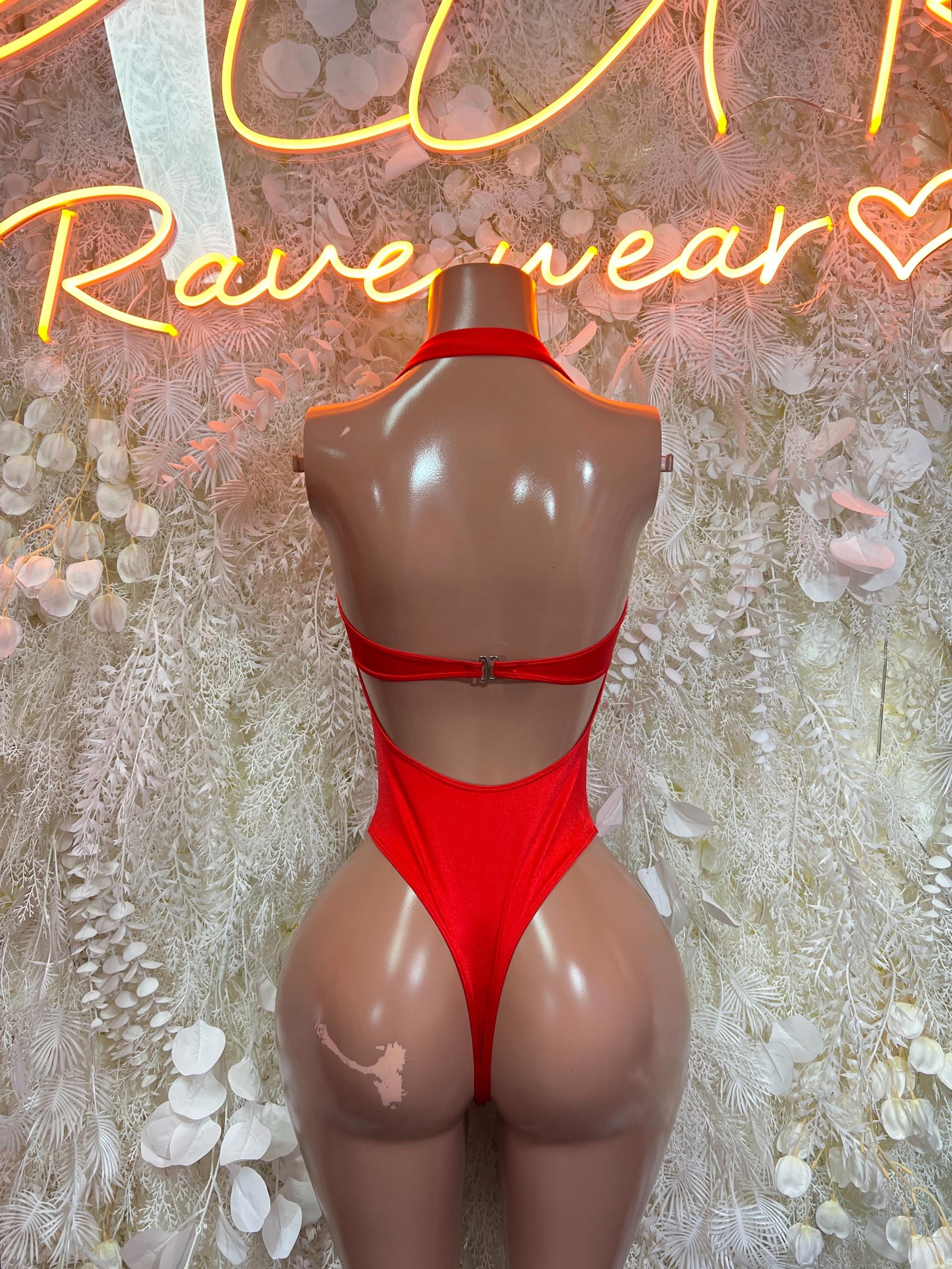 Red halter one-piece bodysuit with open back and cross-strap clasp detail