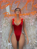 Red velvet one-piece bodysuit with rhinestone accents and deep V neckline