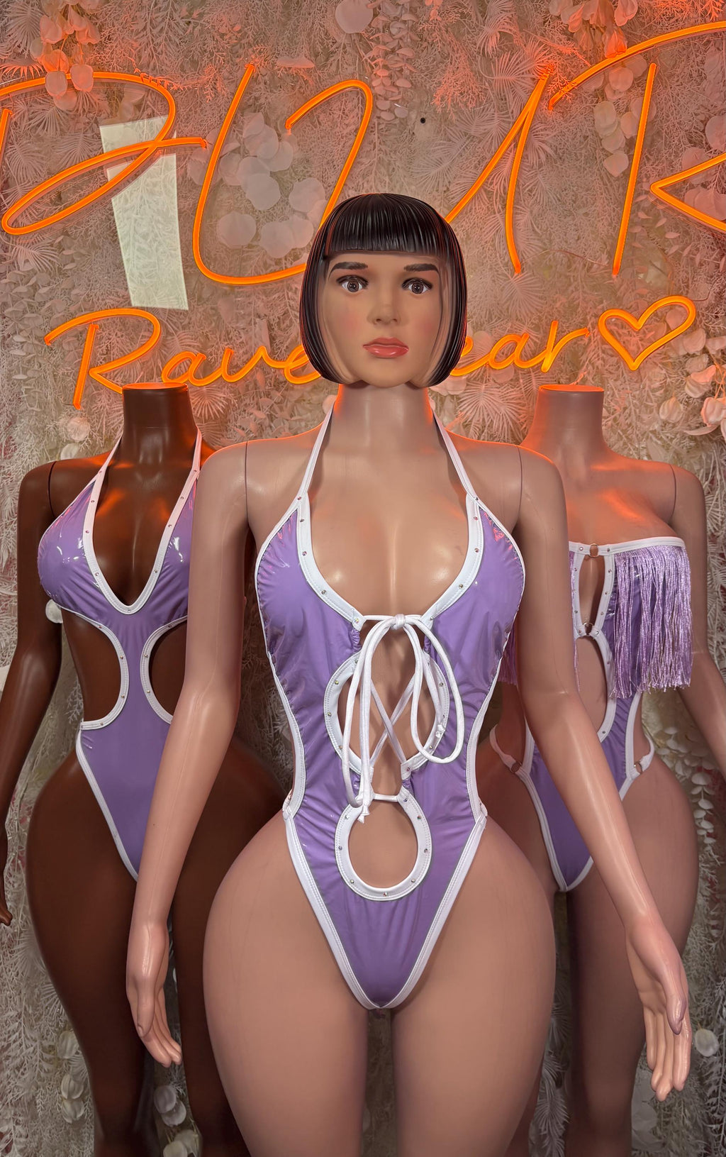 Purple halter bodysuit with white lace-up front and O-ring detail, shoulder fringe