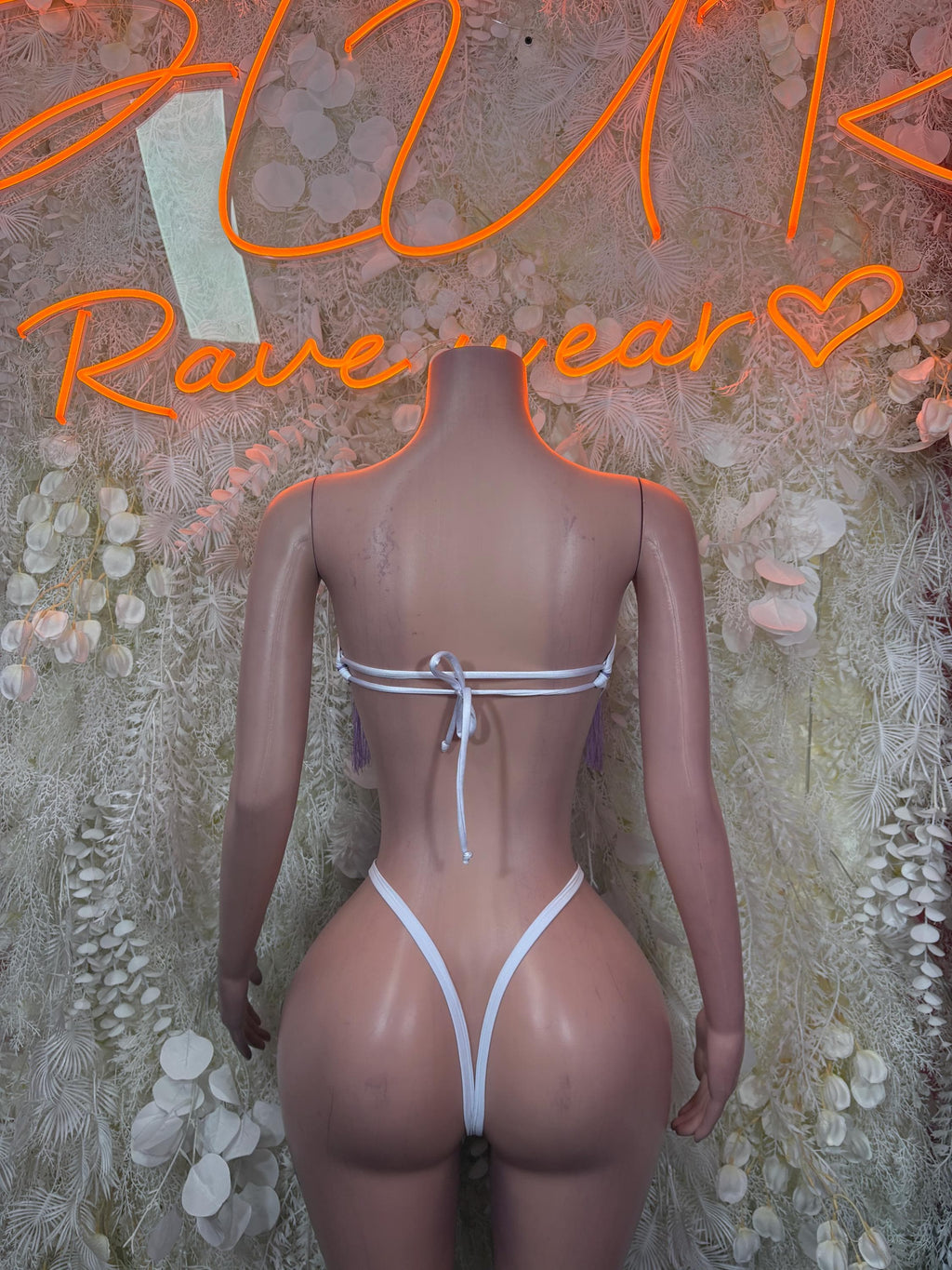 Purple backless rave bodysuit with white straps and tie bow at center back