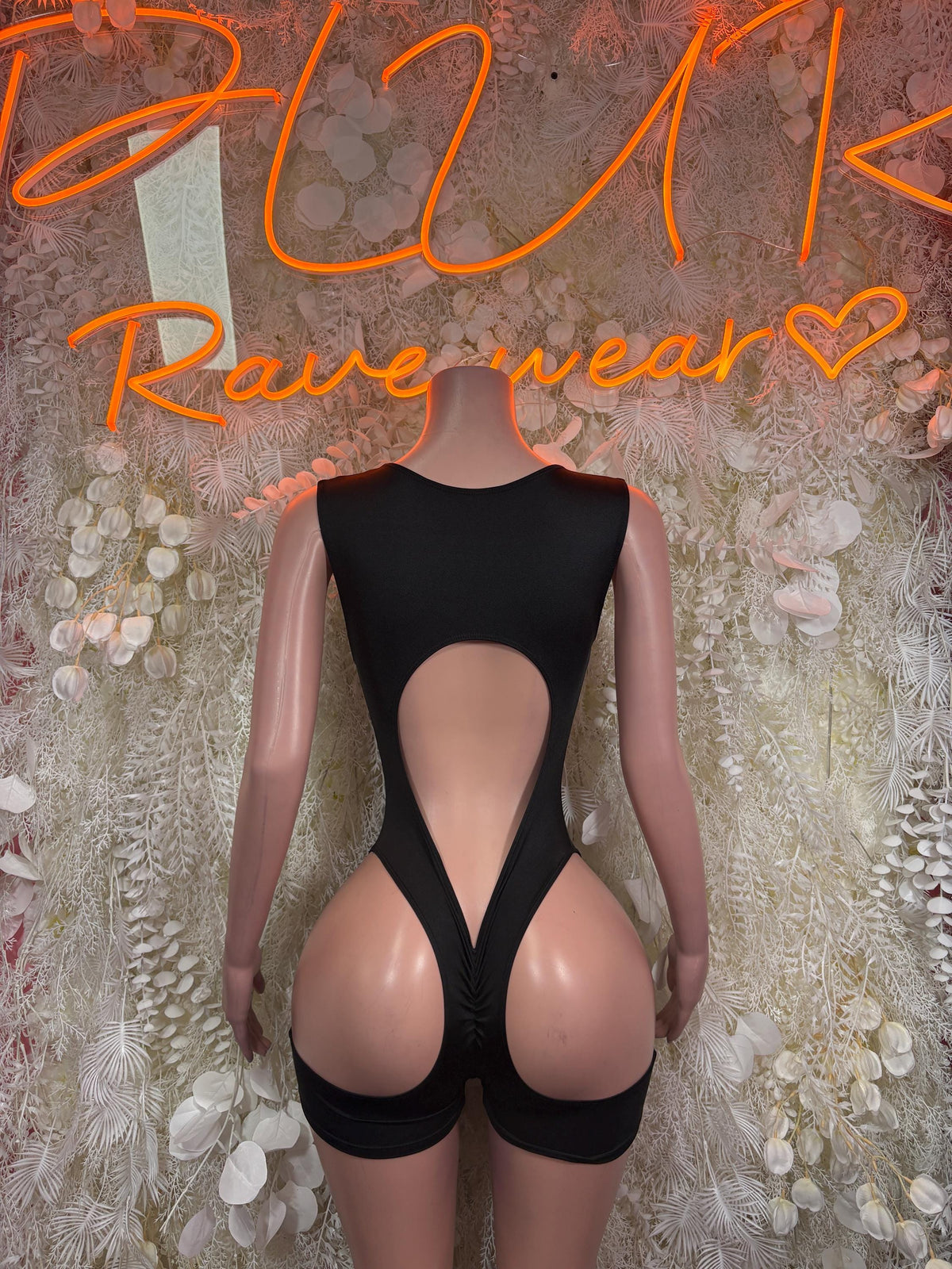 Black referee-style bodysuit with deep front cutout and lace-up center, short bottoms