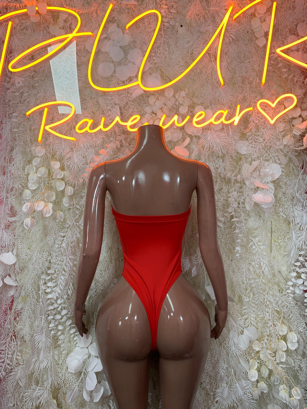 Red one-piece bodysuit with open back and halter-style straps