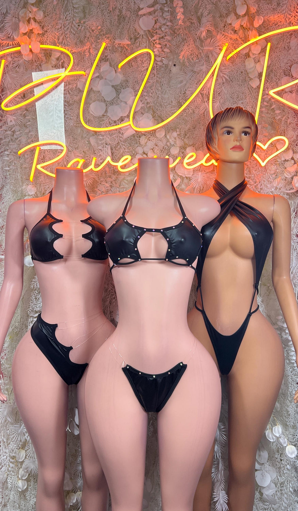 Matte black latex bodysuit with cutout cups, halter straps, and high-cut thong back