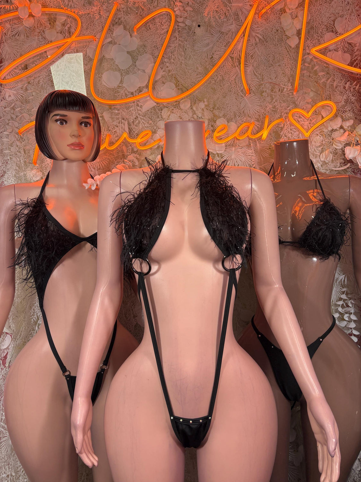 Black slingshot bodysuit with narrow straps, triangular crotch panel, and fringe bust