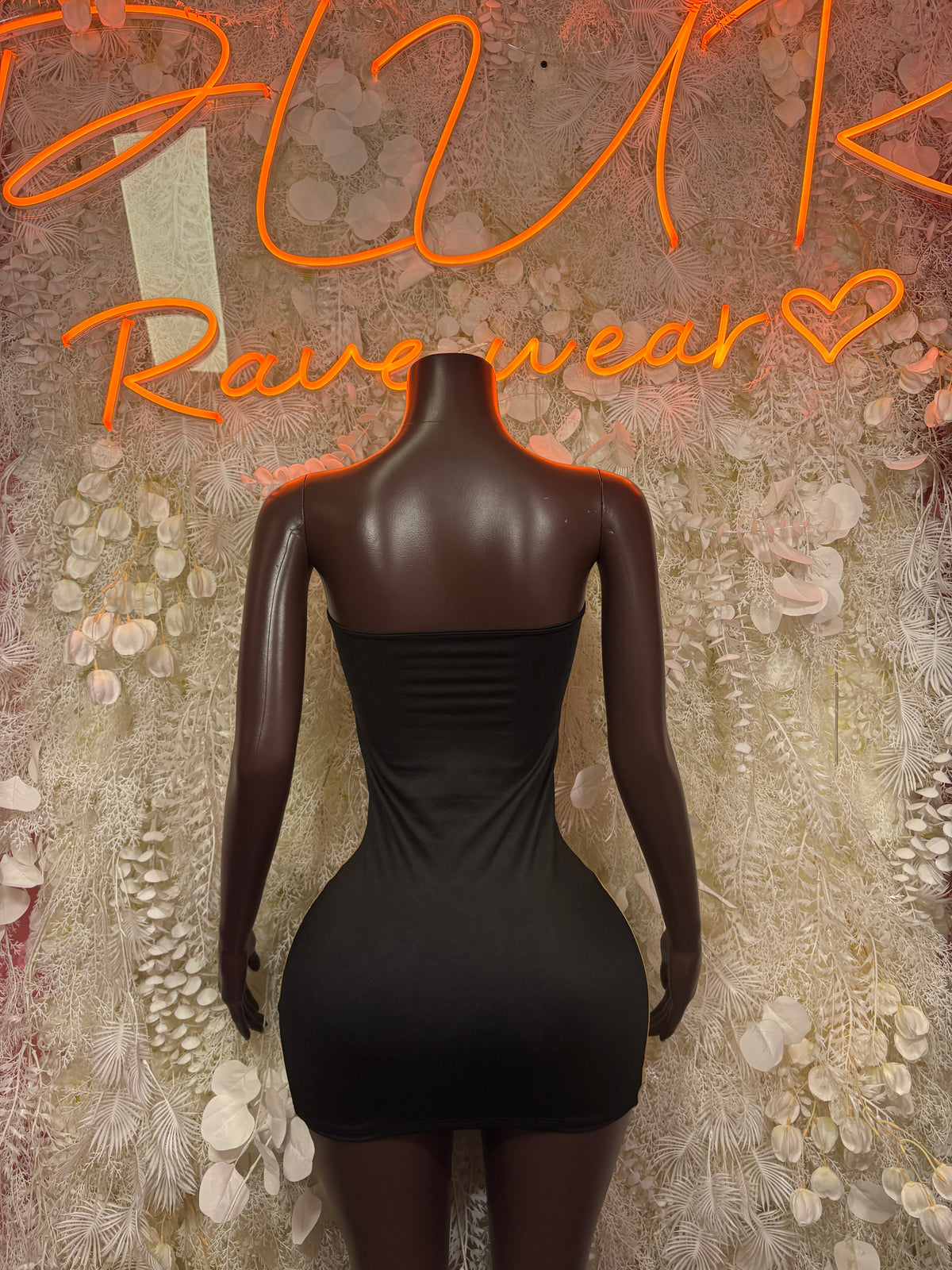 Back view of black cutout bodysuit with high neckline and gathered waist