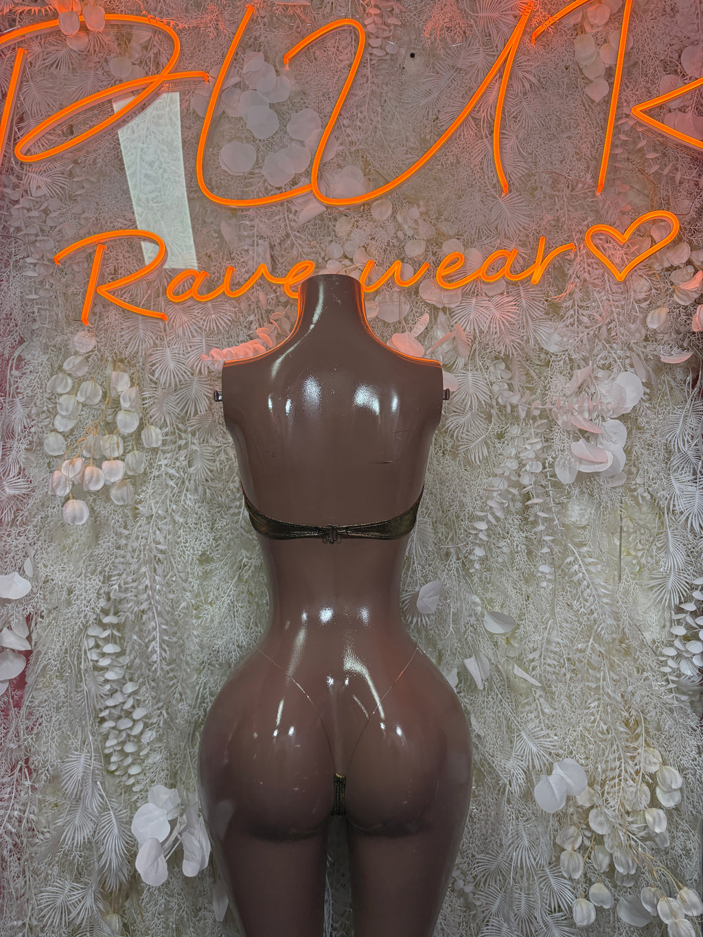 Black cutout bodysuit on a mannequin, with gold metallic bra cups