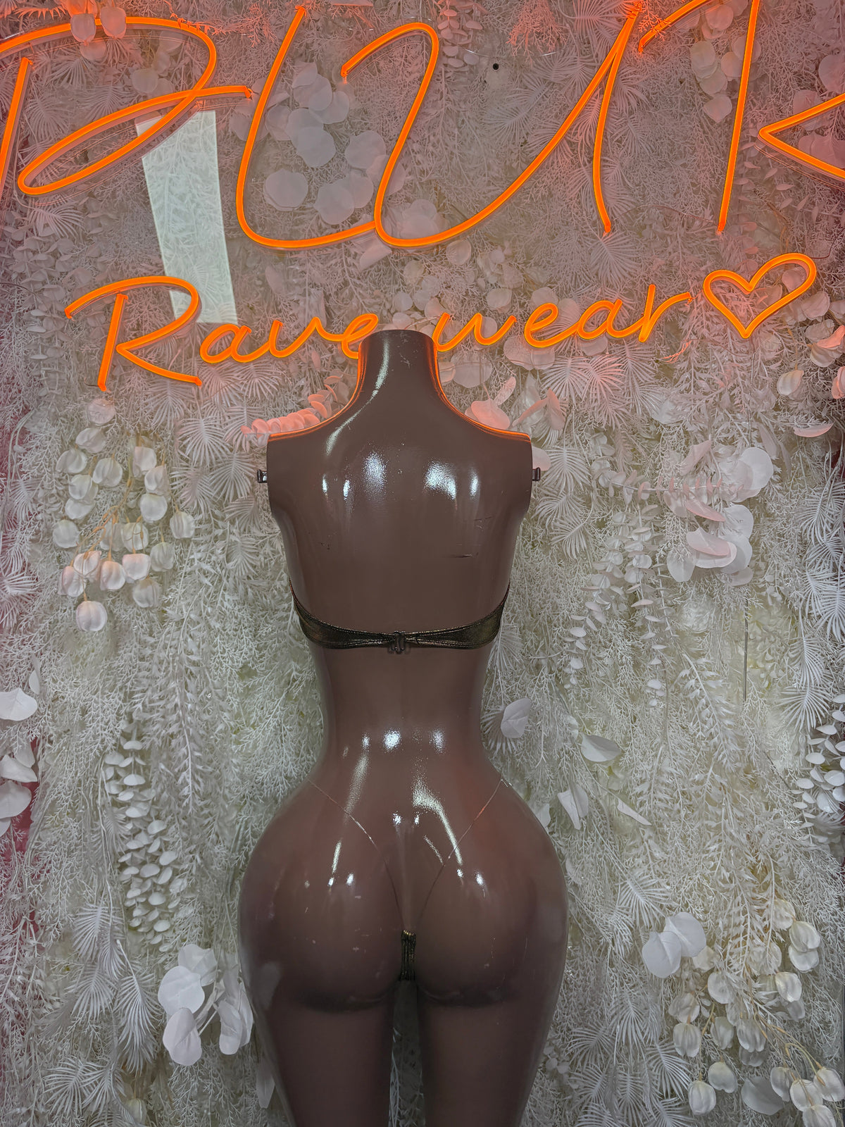 Black cutout bodysuit on a mannequin, with gold metallic bra cups