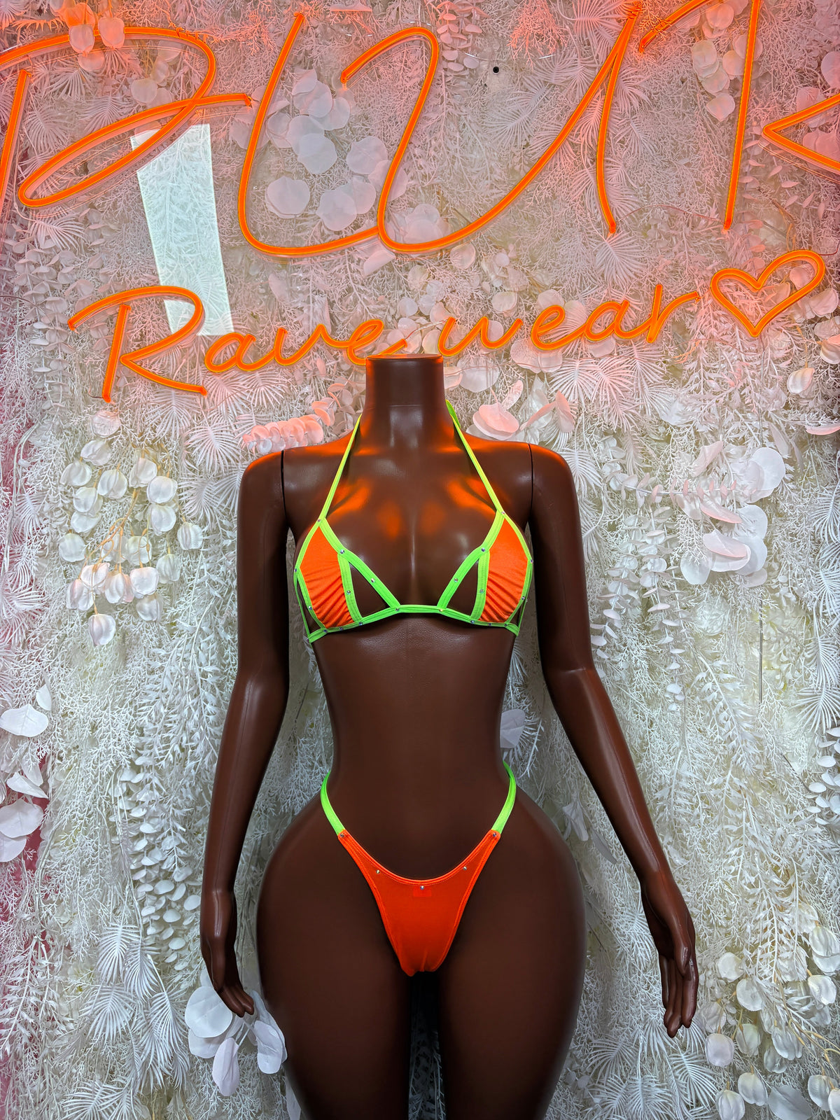 Neon orange strappy bikini with lime green trim, top and thong on mannequin