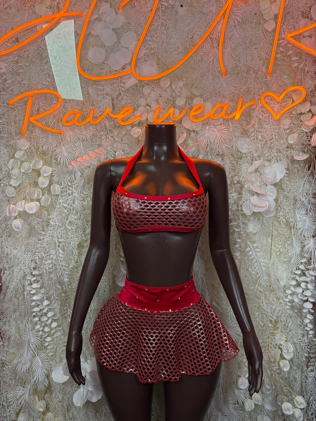 Red/black fishnet halter mini skirt set on mannequin, halter top and flared mini skirt.