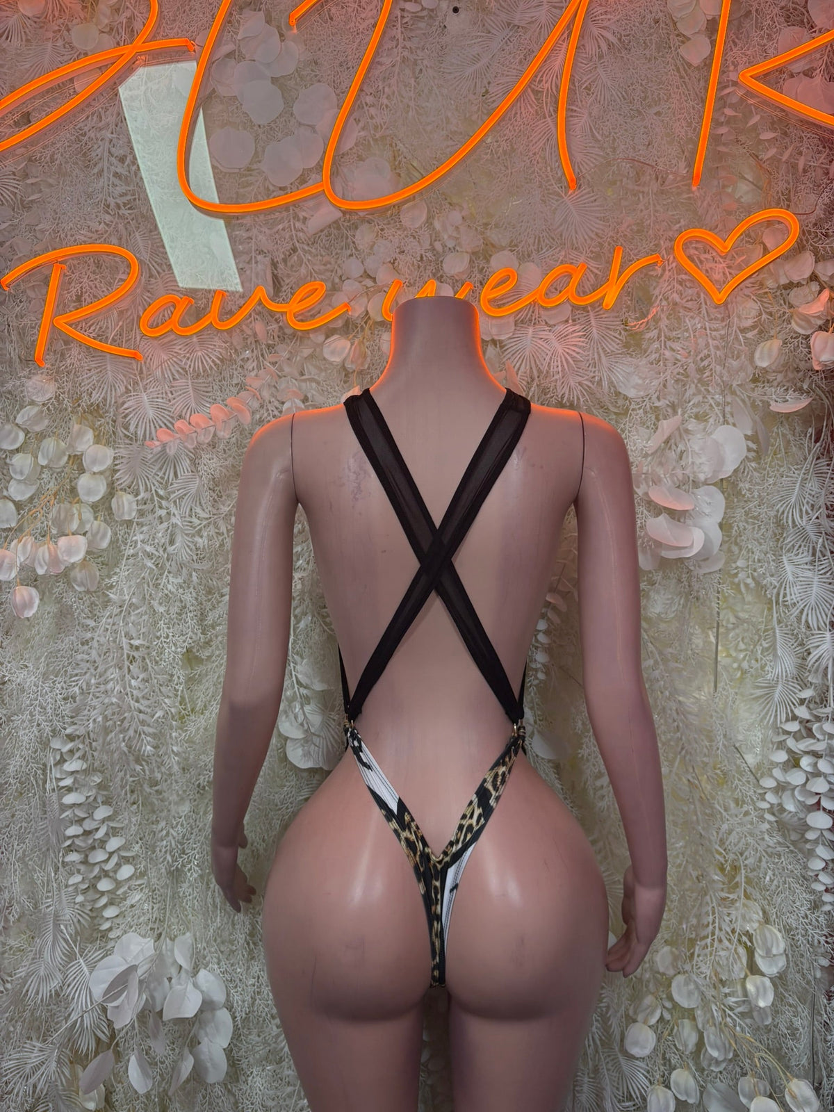 Black halter one-piece with leopard print front, crisscross back straps and high-cut bottom