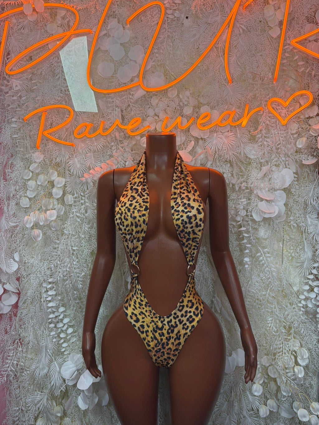 Gold leopard thong bodysuit with halter V-neck and open back on mannequin