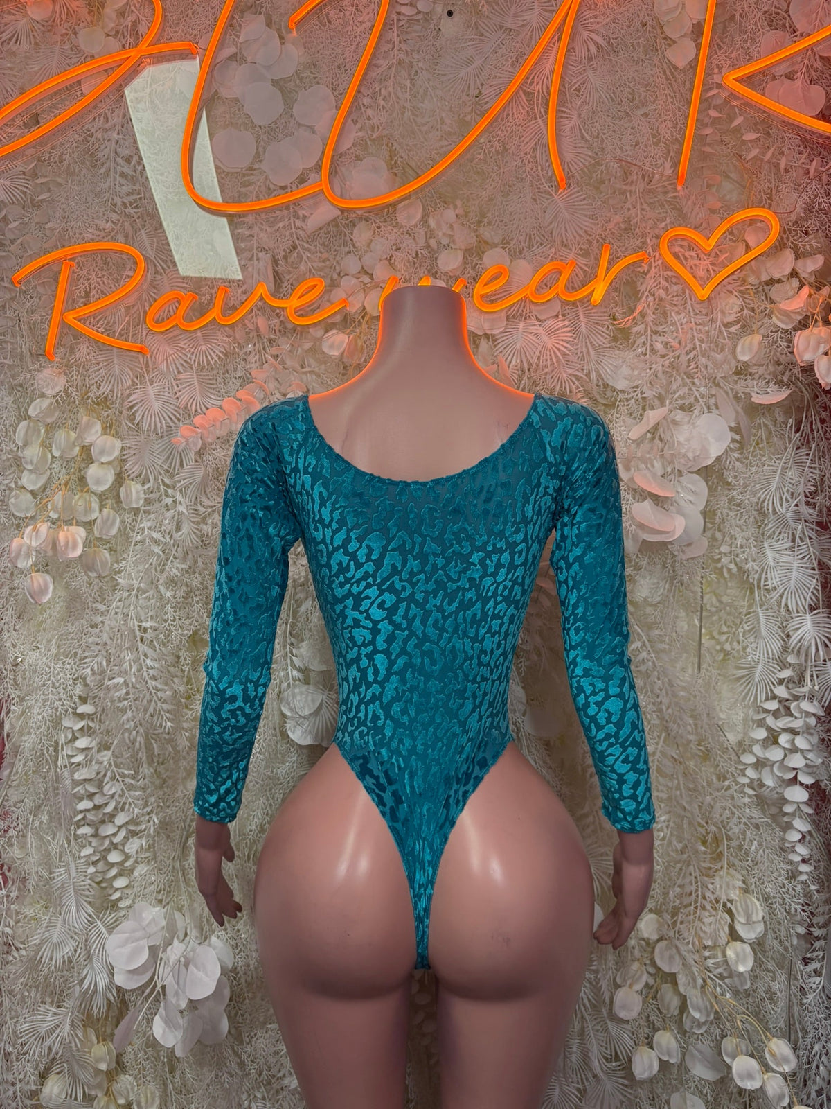Teal glitter bodysuit with long sleeves and open-back V neckline, black print