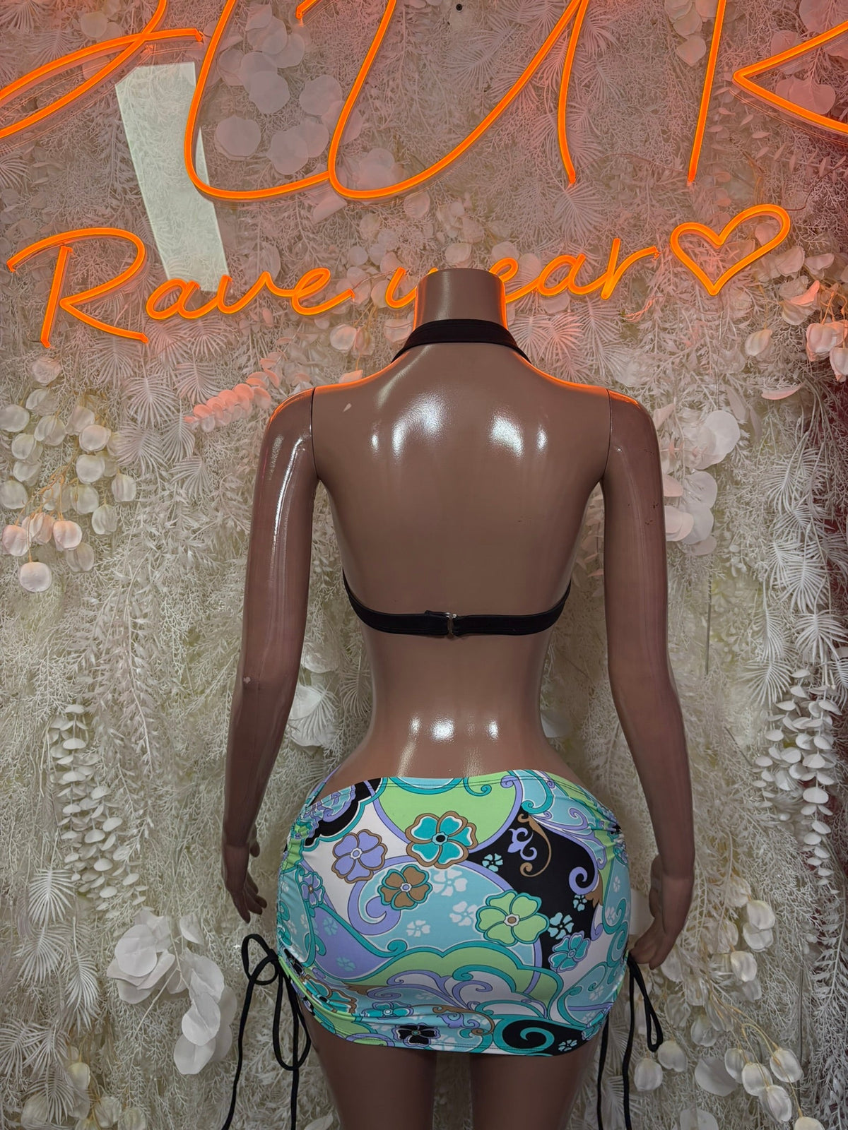 Two-piece festival outfit back view: halter bikini top and mini skirt with tie sides