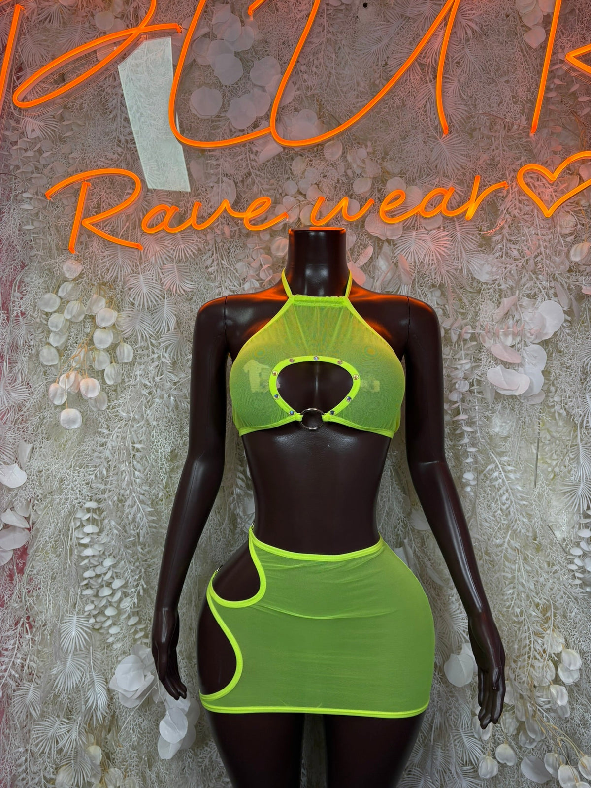 Neon green halter cutout mini dress set with matching mini skirt on mannequin