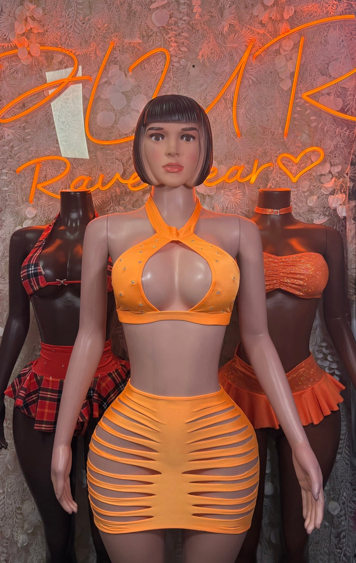 Orange cutout halter crop top with slashed mini skirt set, angled front view