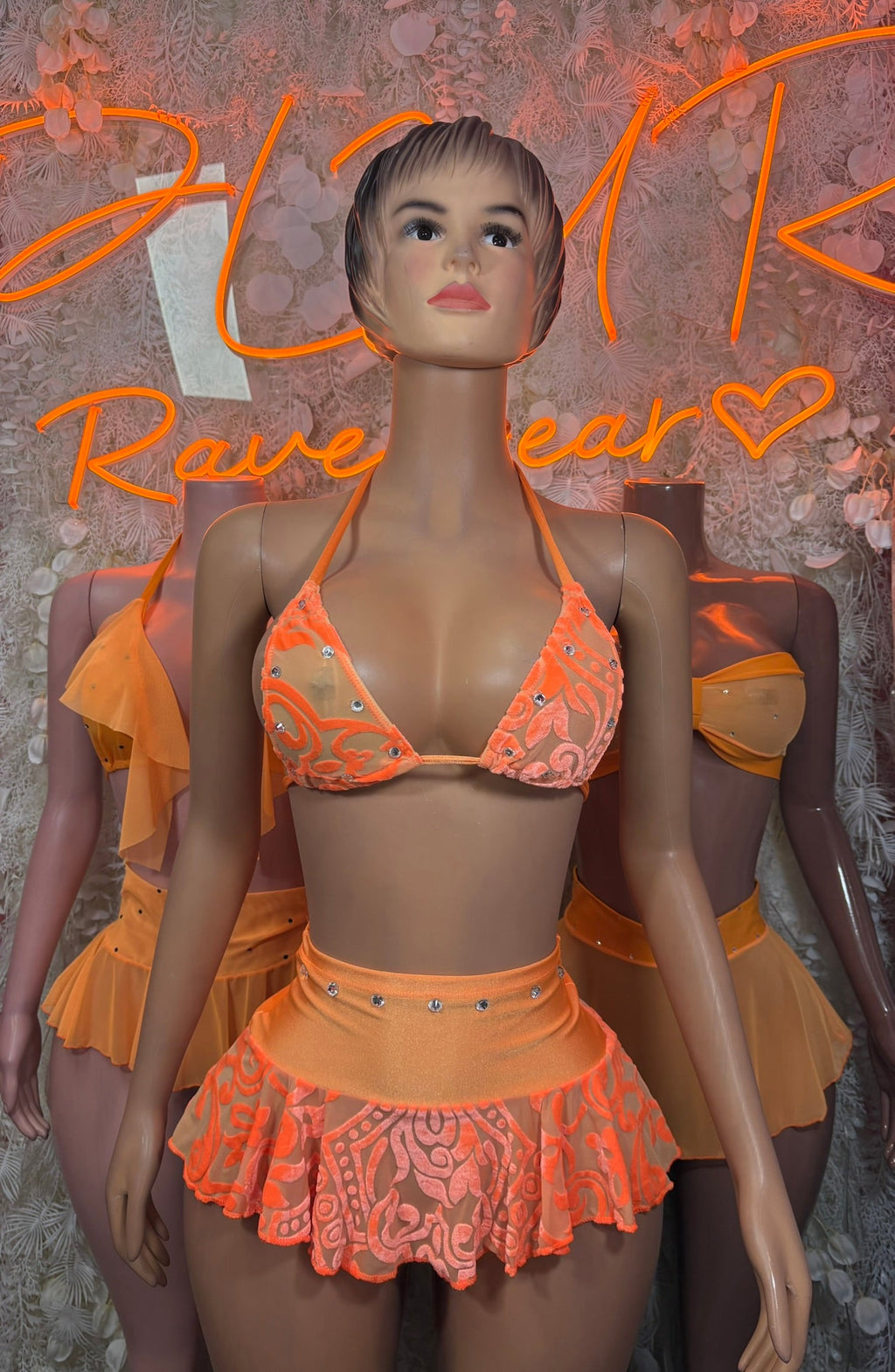 Peach sheer ruffle bikini set on mannequin, triangle bandeau top and flared mini skirt