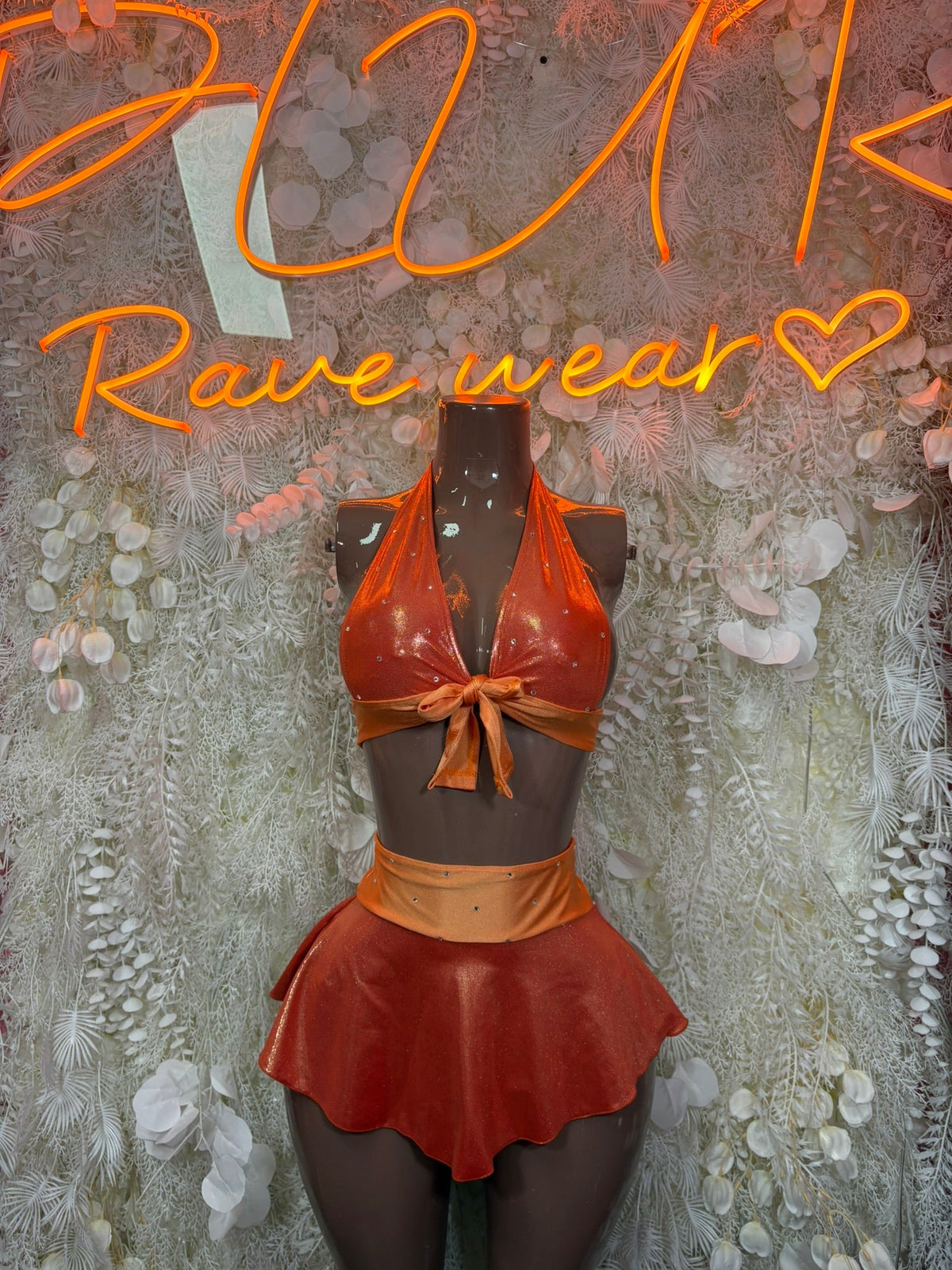 Metallic orange halter top with tie bow and ruffle skirt on mannequin