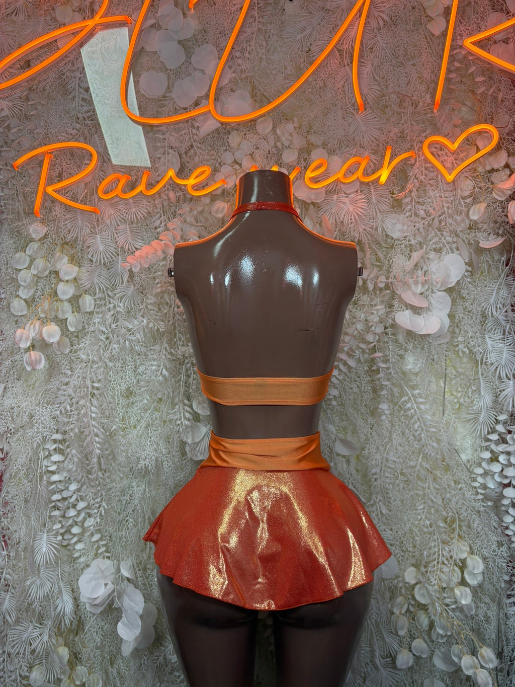 Metallic orange halter top and ruffle skirt set, back view on mannequin