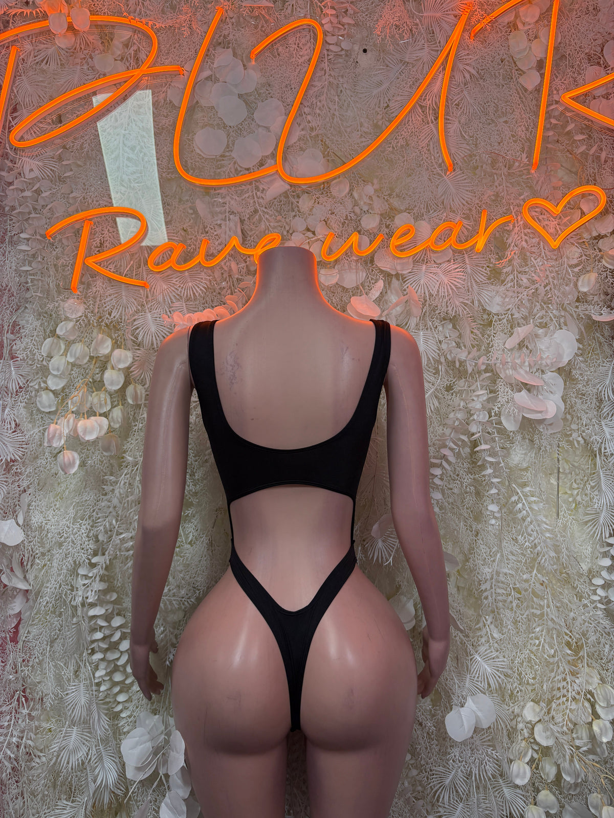 Black bodysuit with racerback straps and open back cutout, high-leg cut