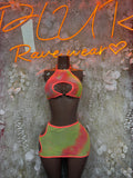 Two-piece festival set: red-orange keyhole mesh crop top with green multicolor mini skirt